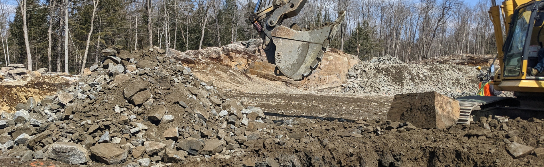 an excavator digging rocks