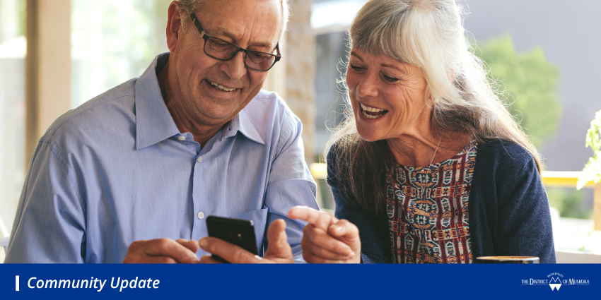 older adults looking at a smart phone smiling